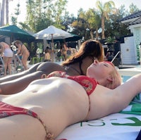 a woman in a bikini laying on the beach